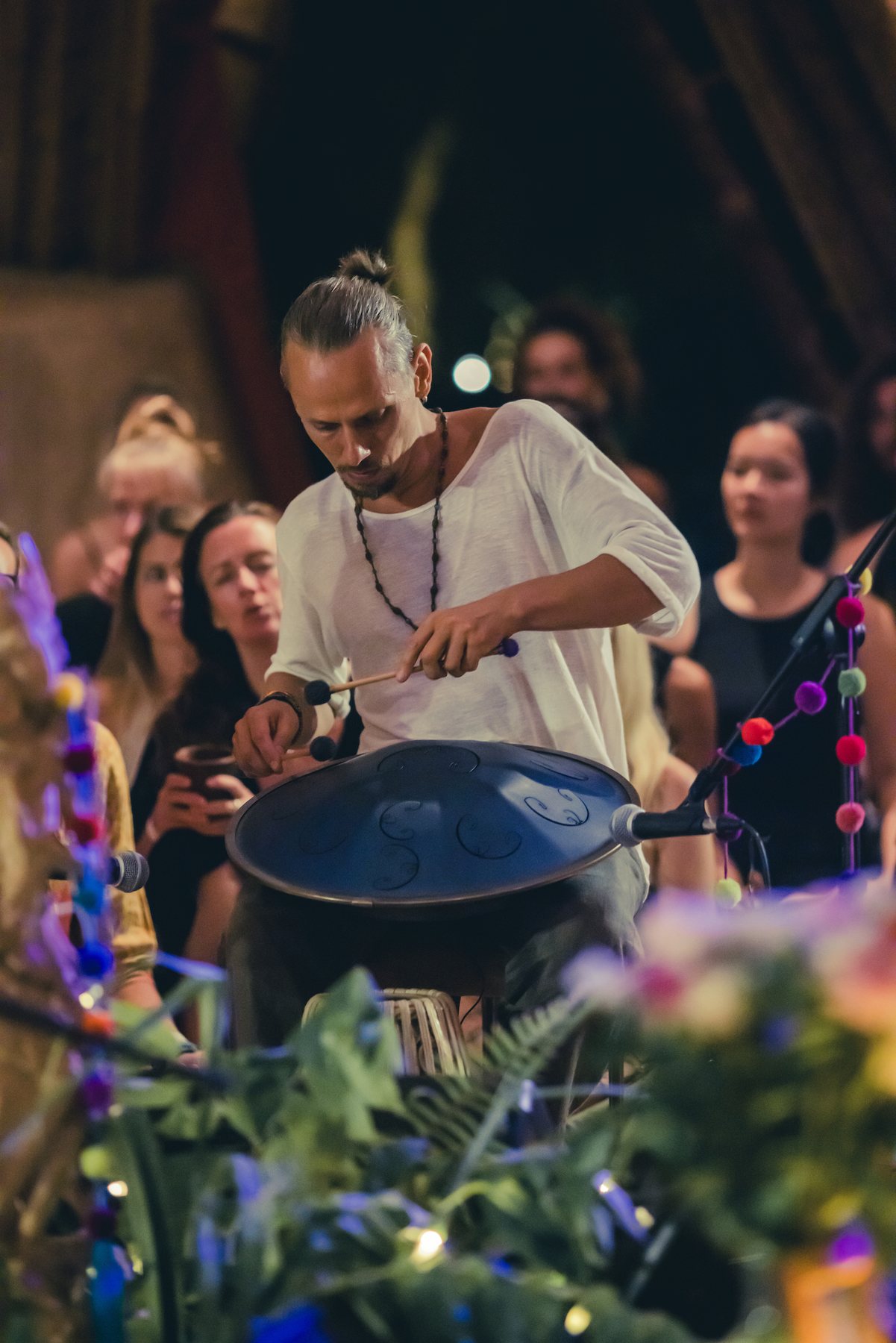 Acharya playing handpan for a gathered crowd